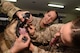 Two female sailors look in a dogs mouth