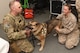 Female sailor and make Airmen hold on to dog