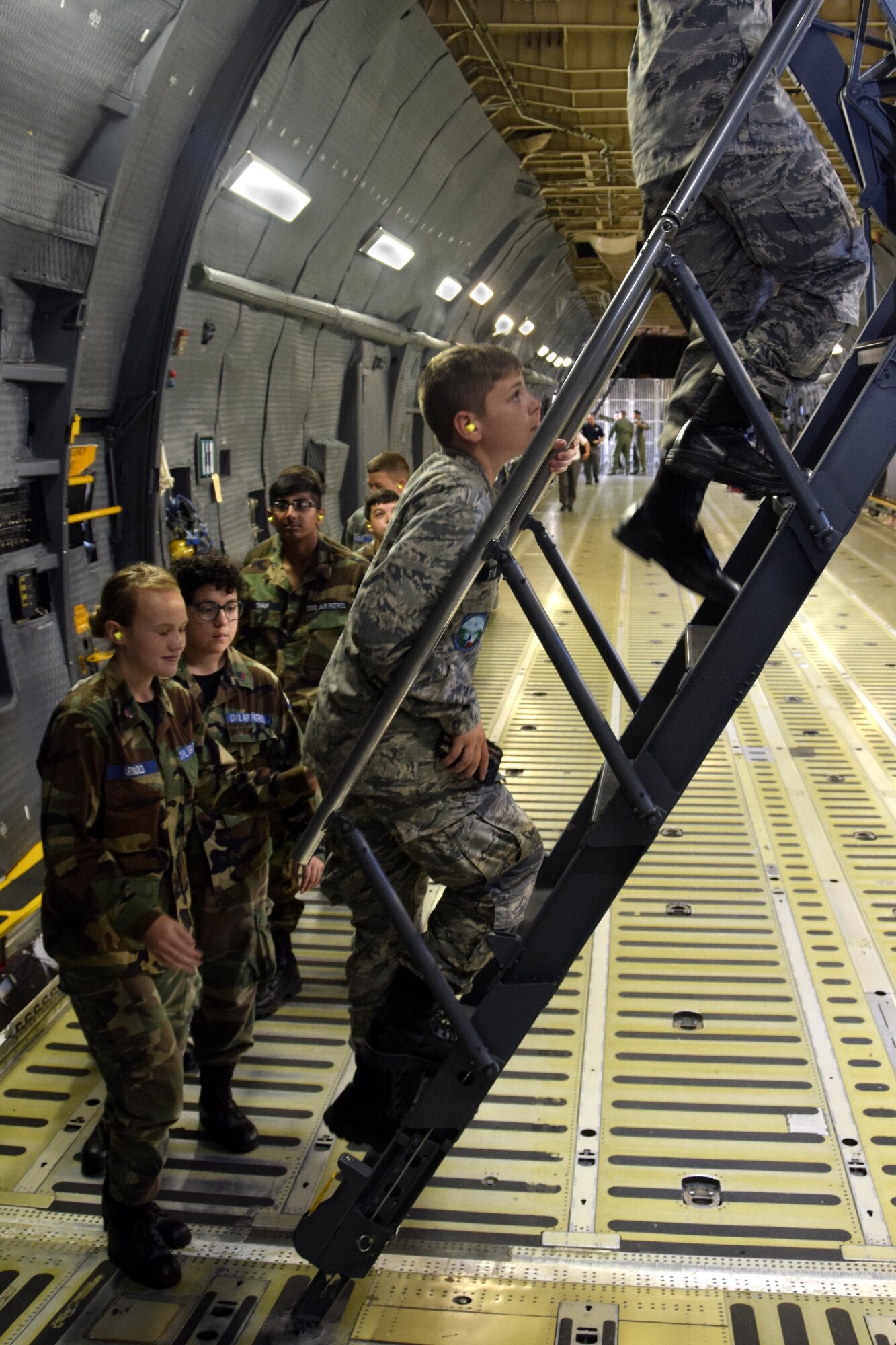 U.S. Air Force Civil Air Patrol cadets climb the rear section’s stairs to the 433rd Airlift Wing C-5M Super Galaxy aircraft’s upper deck at Joint Base San Antonio-Lackland, Texas, June 8, 2018. Members of the official Air Force auxiliary fly nearly 100,000 hours per year performing disaster relief, counterdrug, search and rescue, fighter interceptor training, aerial observation and cadet orientation flights. (U.S. Air Force photo by Staff Sgt. Lauren M. Snyder)