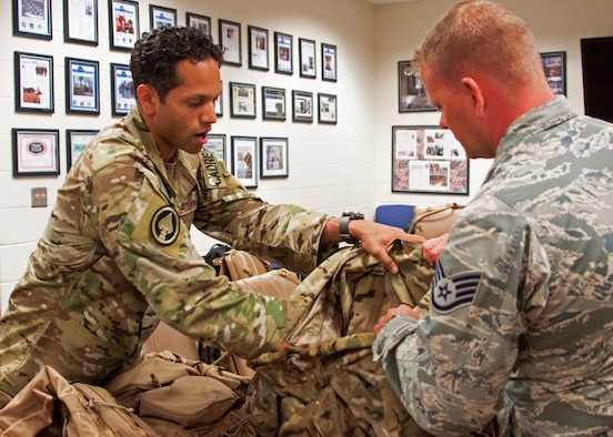 Tech. Sgt. Gabriel Ortiz, a 919th Special Operations Security Forces Squadron cadre member, instructs a fellow squadron member on the most efficient techniques for packing a rucksack