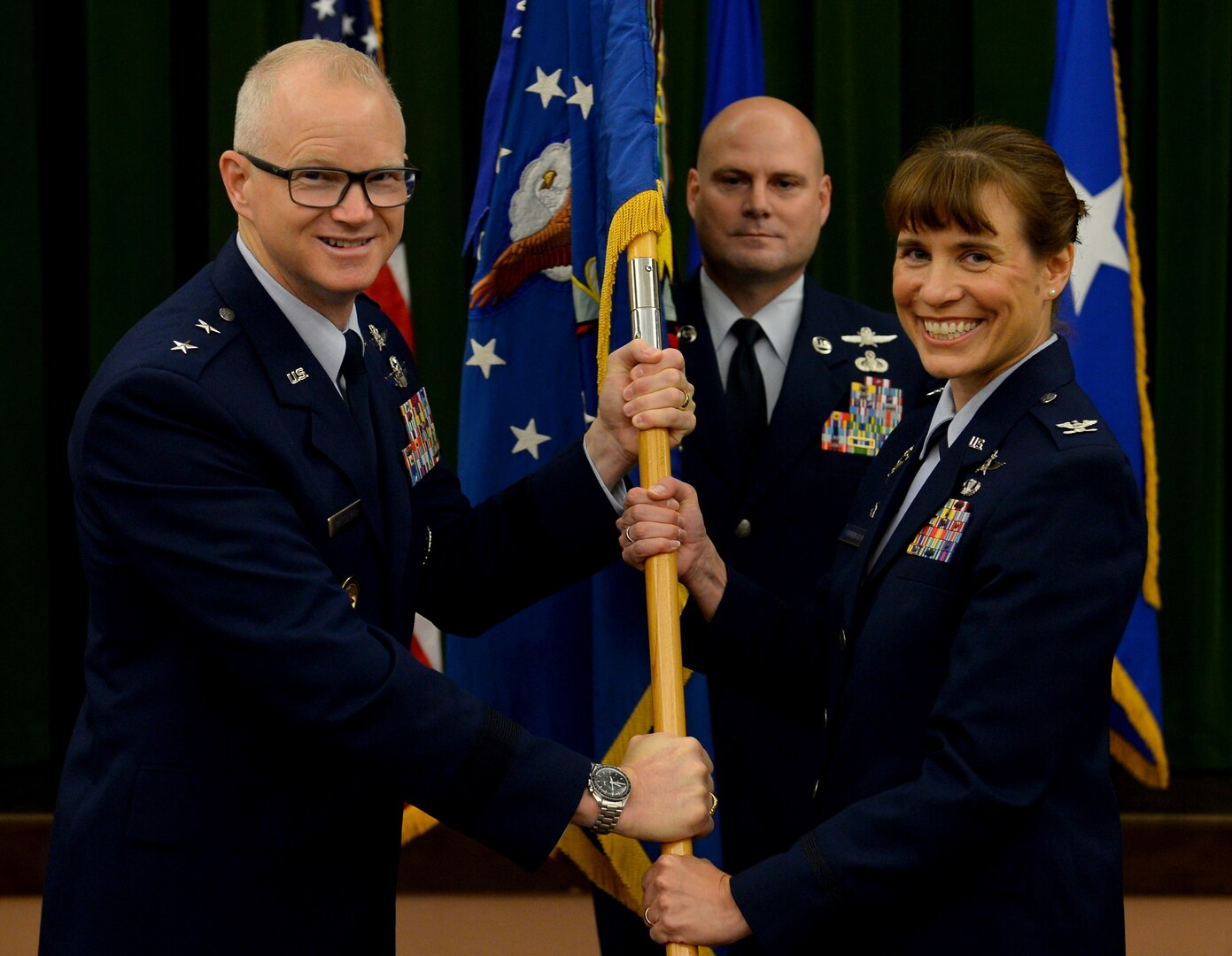 Maj. Gen. Chris Weggeman, Air Forces Cyber commander, presents the 67th Cyberspace Wing guidon to Col. Melissa Cunningham, 67th CW commander, during the wing’s change of command ceremony at Joint Base San Antonio-Lackland, Texas, June 20, 2018. Col. Bradley Pyburn relinquished command of the wing to Cunningham. (U.S. Air Force photo by Tech. Sgt. R.J. Biermann)