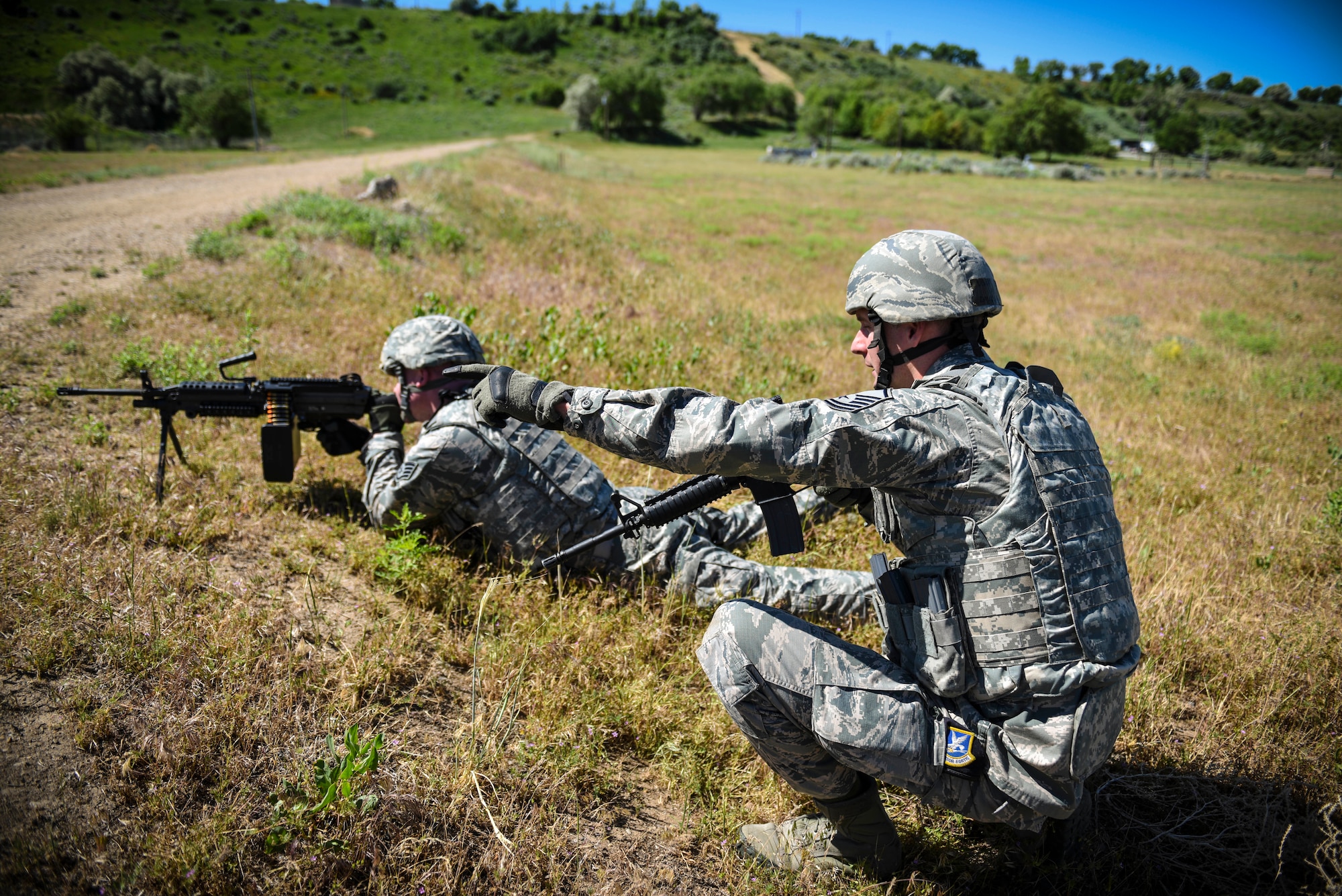 Staff Sgt. Robert Brinton, fire team leader in the 419th Security Forces Squadron, takes aim down range while Master Sgt. David Hasseler, 419th SFS squad leader, provides cover
