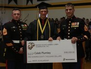 IRON MOUNTAIN, Mich. -- Gunnery Sgt. Pete Vargo and Staff Sgt. Eric Fritz, Recruiting Substation Green Bay Recruiters, presented Caleb Plumley with the Naval Reserve Officers Training Corps Marine scholarship at graduation from Iron Mountain High School. NROTC trains future leaders in the Navy and Marine Corps while they attend college.  Plumley plans to become a Marine Corps officer after graduation from the University of Michigan. (U.S. Marine Corps photo by Cpl. Emma S. Norris)