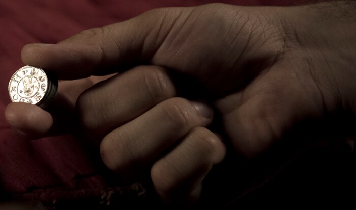 U.S. Air Force Senior Airman Benjamin Lanteigne, 628th Security Forces Squadron patrolman, holds coins used for his war reenactments June 14, 2018.