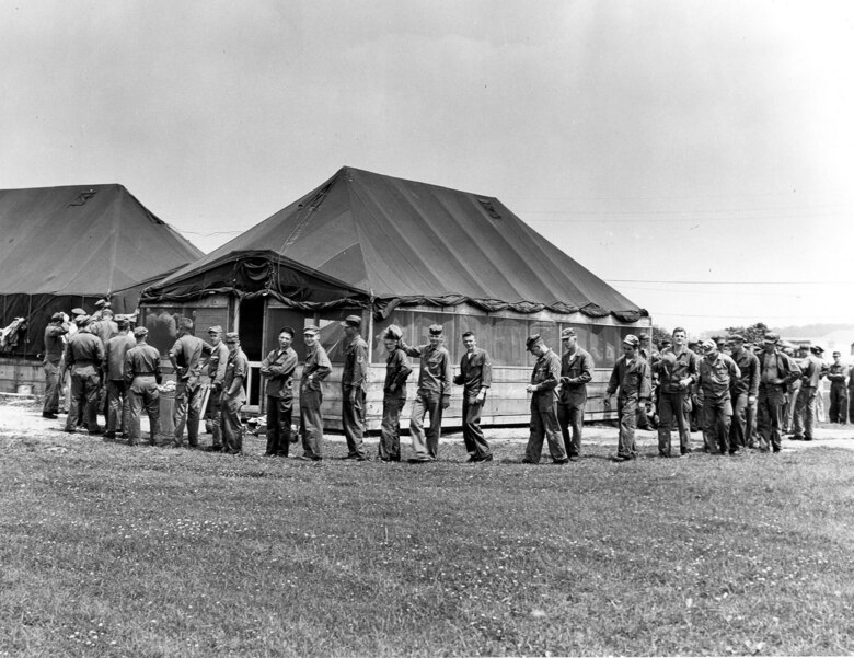 Airmen wait in line for a mean during summer training encampment June 16-17, 1956 at Camp Williams (now Volk Field), Wis.