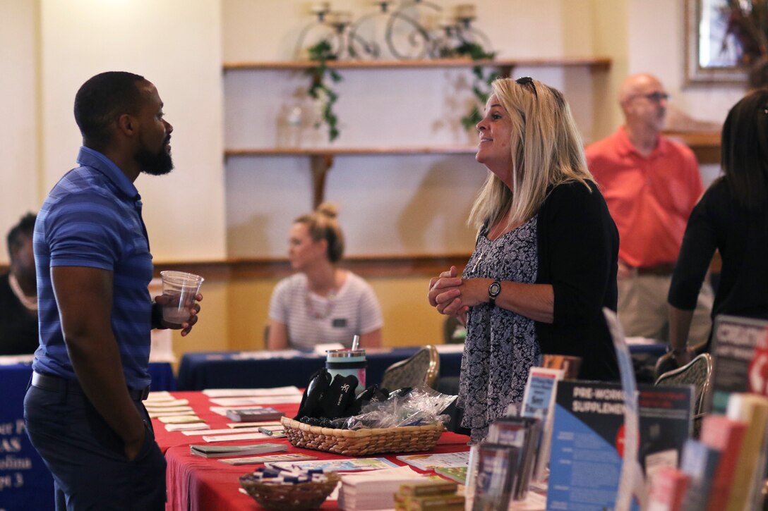 Harriet Fisher speaks to a participant at the Career, Education, and Health Fair aboard Marine Corps Air Station Beaufort June 19. The Marine Corps Community Services
sponsored event was held so attendees could meet potential employers, college representatives and fitness experts. Fisher is a Kinesiotherapist with MCCS.