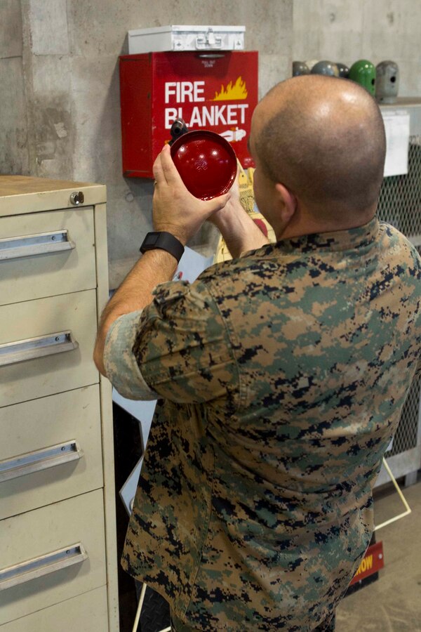 Master Gunnery Sgt. Steven R. Kerste, the safety chief for 3rd Marine Logistics Group, inspects the date on a fire extinguisher during a routine safety inspection of the metalworking shop on Camp Kinser, Okinawa, Japan, June 8, 2018. Kerste was awarded the 2017 Marine Corps Safety Award for his excellence and innovation in the field of safety. Kerste is a native of Moreno Valley, California. (U.S. Marine Corps photo by Lance Cpl. Jamin M. Powell)