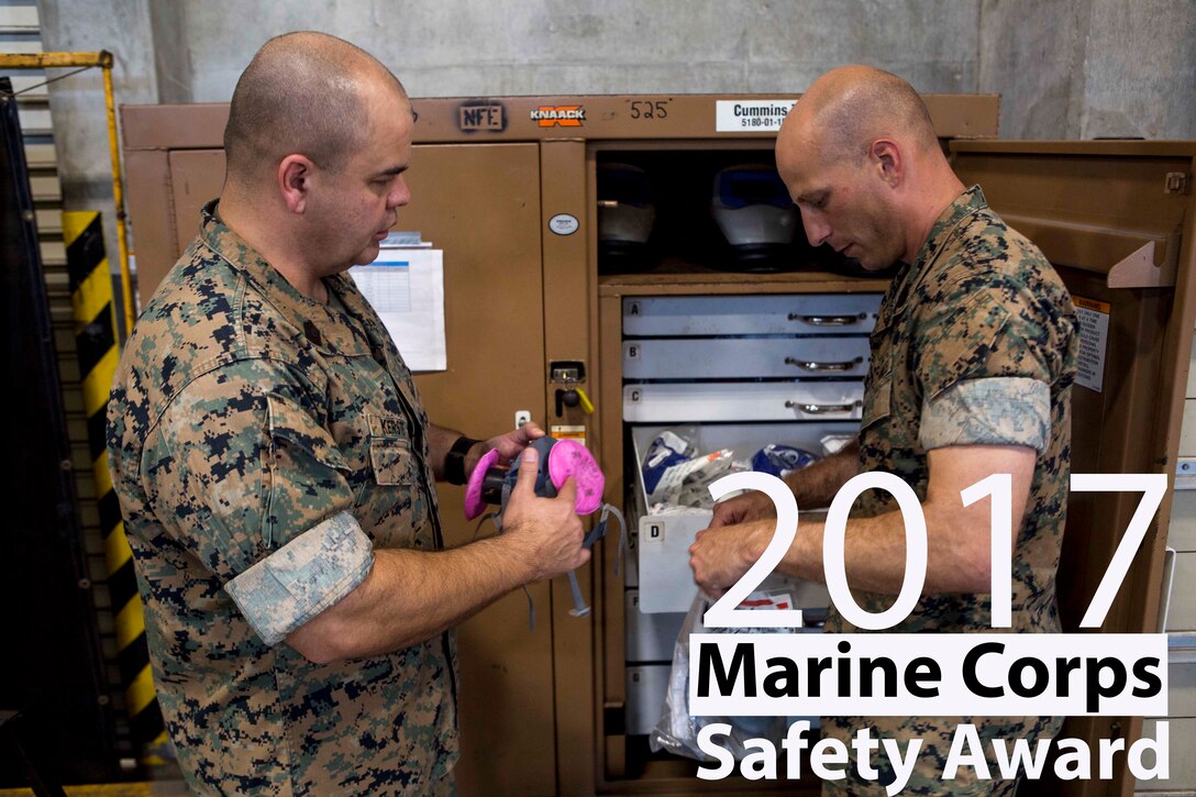 Gunnery Sgt. Justin Horn, right, holds a mask while Master Gunnery Sgt. Steven R. Kerste, left, the safety chief for 3rd Marine Logistics Group, inspects equipment during a routine safety inspection of the metalworking shop on Camp Kinser, Okinawa, Japan, June 8, 2018. Horn is the staff noncommissioned officer in chargeof the metalworking shop with 3rd Maintenance Battalion, 3rd MLG. Kerste was awarded the 2017 Marine Corps Safety Award for for his excellence and innovation in the field of safety. Kerste is a native of Moreno Valley, California. Horn is a native of Green, New York. (U.S. Marine Corps photo by Lance Cpl. Jamin M. Powell)