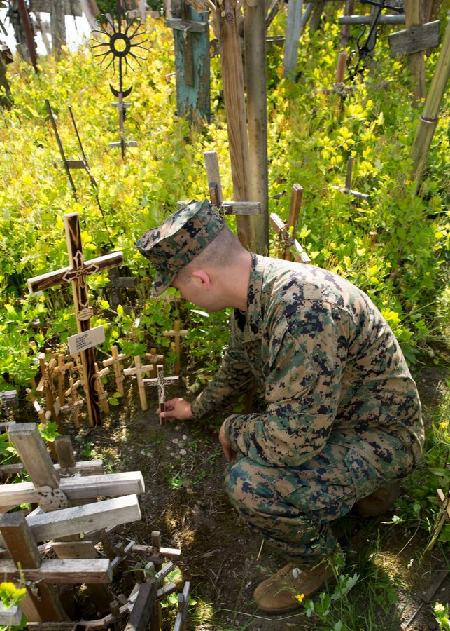 U.S. Marine with 2nd Civil Affairs Group places a wooden cross at the historical Hill of Crosses in Siauliai, Lithuania, June 8, 2018, during Exercise Saber Strike 18. The Marines participating in Saber Strike 18, a U.S. joint and multinational exercise conducted at various locations throughout the Baltic States and Poland, took an opportunity to visit the historic site to recognize and learn some of the culture of Lithuania. (U.S. Marine Corps photo by Sgt Adwin Esters/Released)