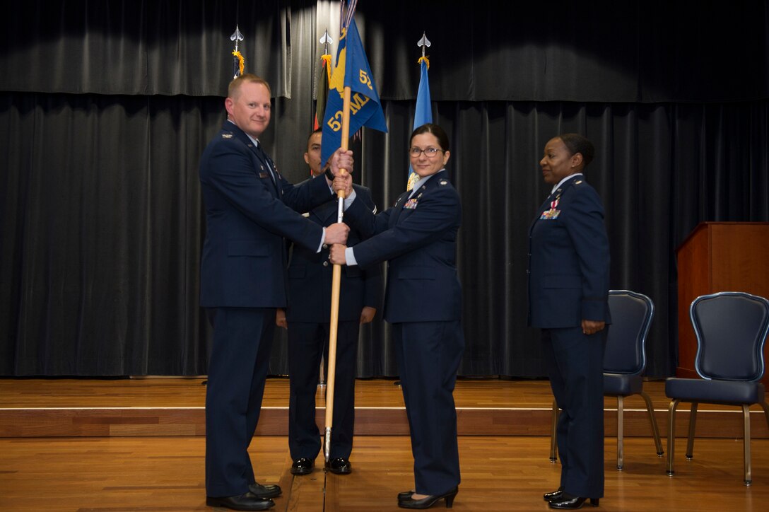 U.S. Air Force Col. Edward Lagrou, 52nd Medical Group commander, left, gives the ceremonial guidon to U.S. Air Force Lt. Col. Nisa Pistone, incoming 52nd Medical Operations Squadron commander, during the 52nd MDOS change of command ceremony on Spangdahlem Air Base, Germany, June 19, 2018. (U.S. Air Force photo by Senior Airman Dawn M. Weber)
