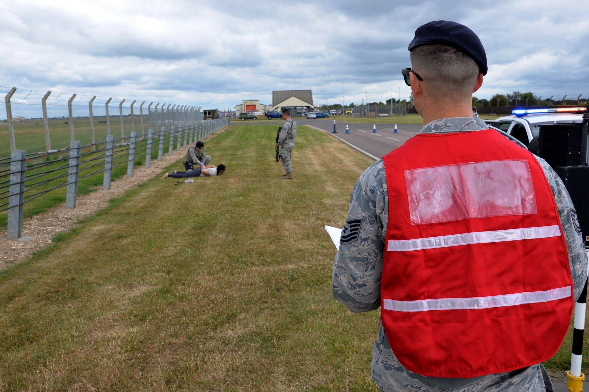 A member of the 100th Air Refueling Wing inspection team observes as U.S. Airmen from the 100th Security Forces Squadron search a simulated suspect during an exercise at RAF Mildenhall, England, June 20, 2018. Such exercises are regularly scheduled to test responsiveness and readiness of base personnel. (U.S. Air Force photo by Tech. Sgt. David Dobrydney)