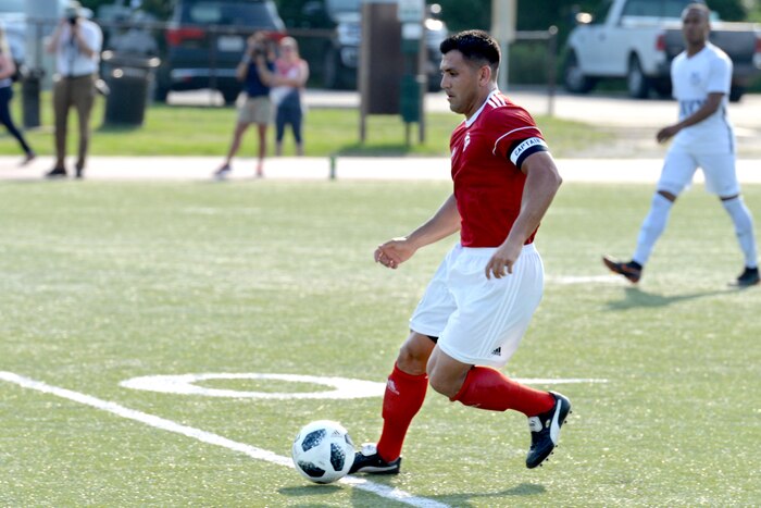 A soccer player kicks a soccer ball.
