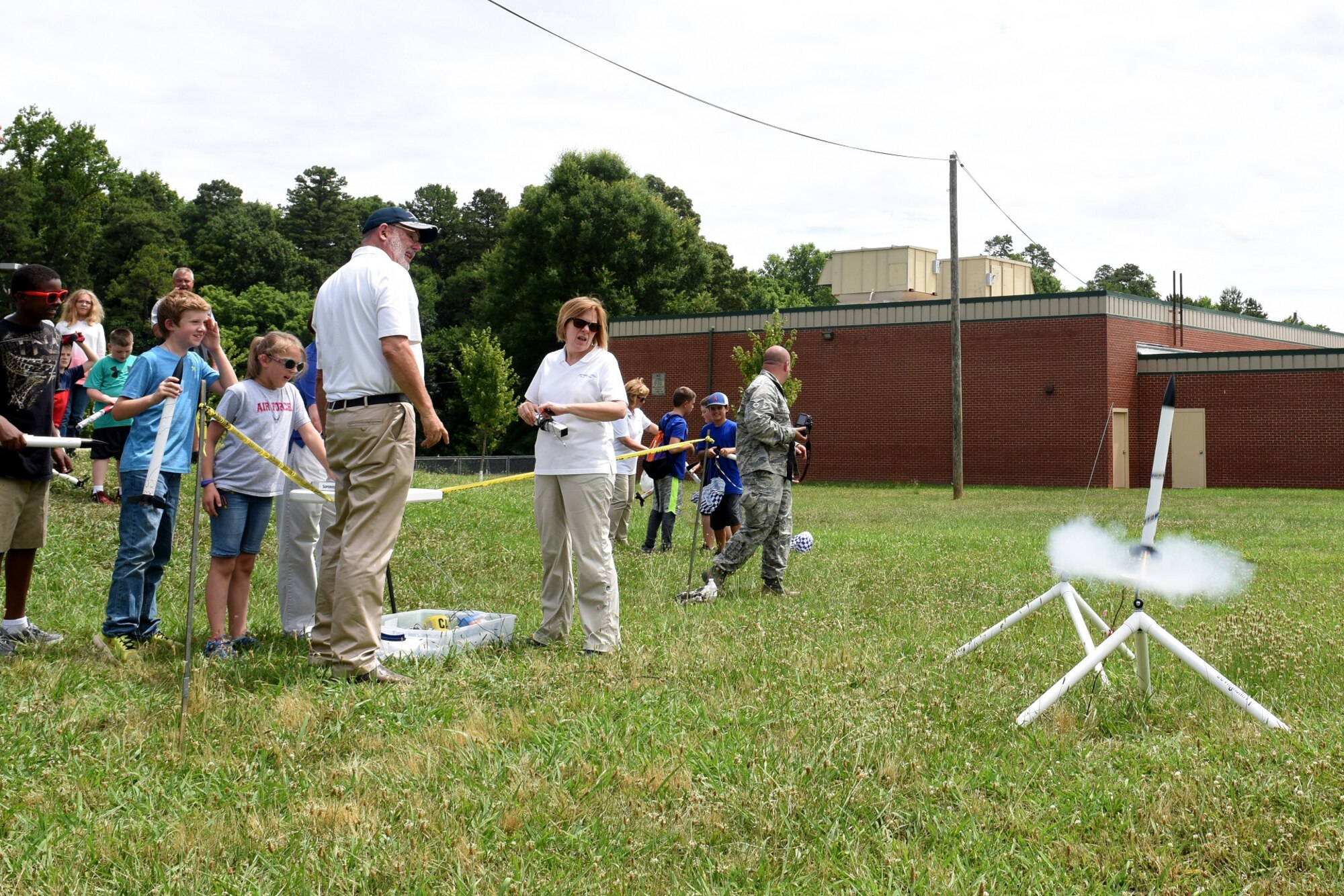 Parents, campers, and teachers watch as model rockets launch near Reid Park Academy Charlotte, N.C., June 21, 2018. The campers and teachers are part of the annual Department of Defense STARBASE summer camp program with the North Carolina Air National Guard and they learn various applications of science, technology, engineering, and math.