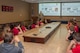 U.S. Air Force Master Sgt. Jeff Williams, 557th Weather Wing wing inspection team manager, gives students from the University of Nebraska-Lincoln Weather Camp a weather wing mission brief June 12, 2018, Offutt Air Force Base, Nebraska. The campers toured the building and learned about career opportunities in Air Force Weather. (U.S. Air Force photo by Paul Shirk)
