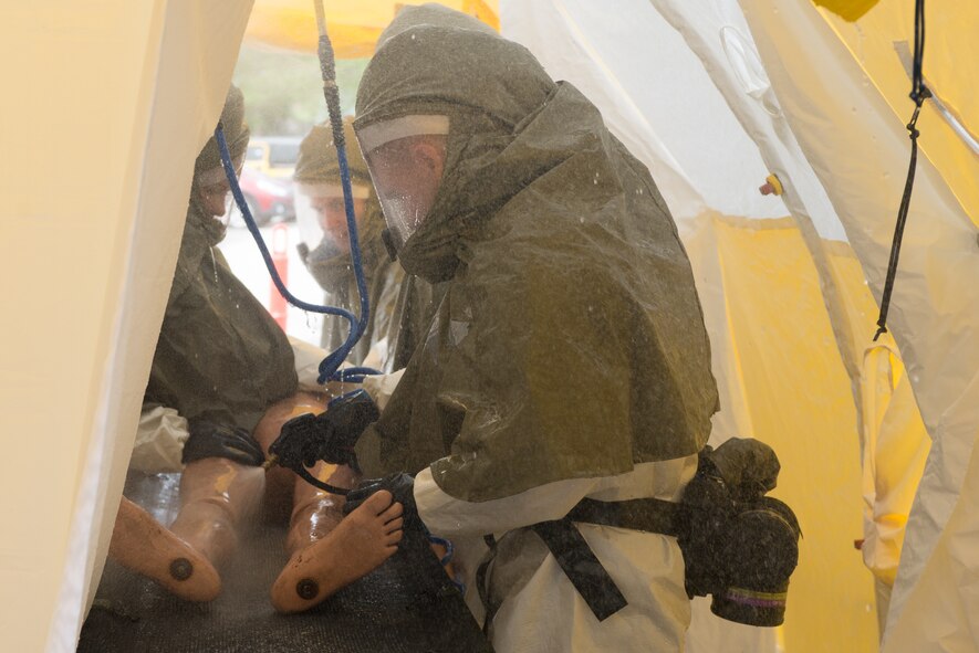 Members of the In-Place Patient Decontamination Team decontaminate a simulated patient during a product evaluation at the Ehrling Bergquist Clinic June 7, 2018, at Offutt Air Force Base, Nebraska. The team set up, operated and tore down the systems several times to determine the merits of each candidate system. (U.S. Air Force photo by Paul Shirk)