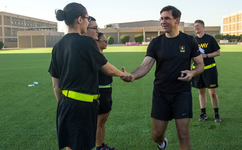 Secretary of the Army, Dr. Mark T. Esper, presents U.S. Army Spc. Toni Johnson, human resource specialist, assigned to the 101st Human Resource Company, with the Secretary of the Army coin for her ingenuity and commitment to her unit, during physical readiness training with Soldiers from the 49th Theater Gateway Company at Camp Arifjan, Kuwait, June 21, 2018. The secretary was honored to award Johnson with her first achievement coin.