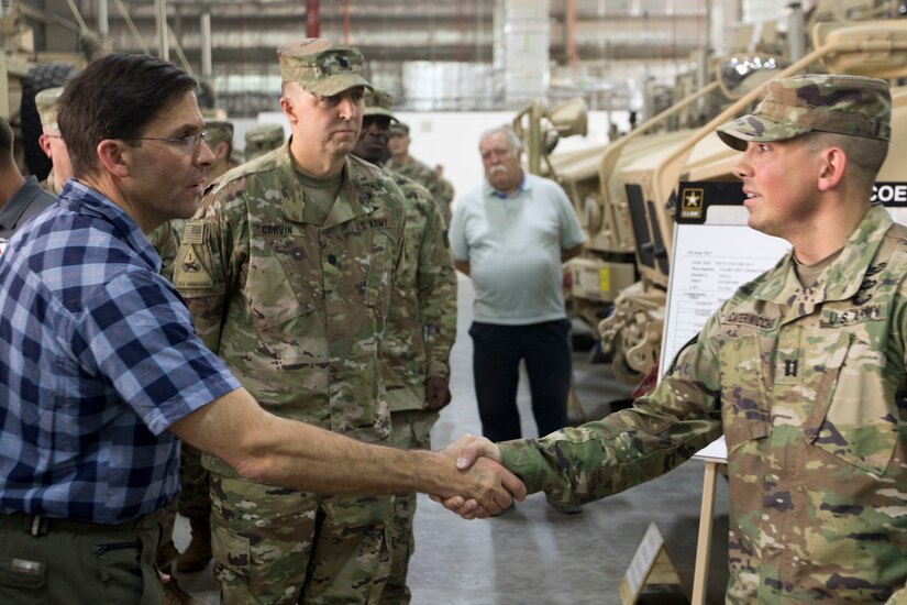 Secretary of the Army, Dr. Mark T. Esper shakes hands with U.S. Army Cpt. Derek A. Caterinicchio, a supply officer with the 401st Army Field Support Battalion, during a tour of an Army Prepositioned Stock warehouse at Camp Arifjan, Kuwait, June 21, 2018. Part of the 401st AFSB's mission in Kuwait is to keep vast stores of equipment ready to be rapidly deployed by units entering Central Command's area of responsibility.
