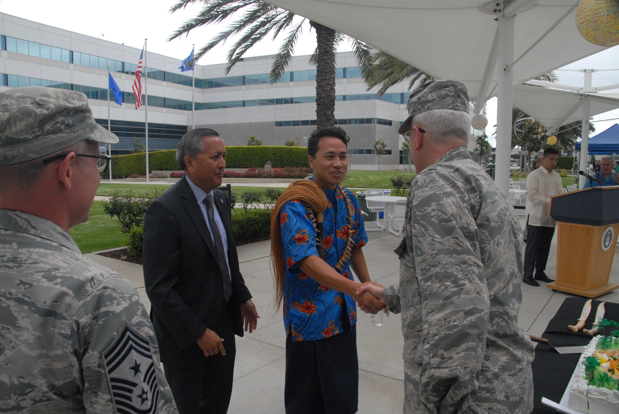 Brig. Gen. Philip A. Garrant, SMC vice commander, Chief  Master Sgt. Scott A. Myers, SMC Command Chief, and Mr. Cordell A. DeLaPena, director of SMC’s Program Management and Integration Directorate, say “Talofa” (Hello) to Charles Ulualofaiga Coleman II, after his opening remarks at the 25th annual Asian Pacific Islander Heritage Celebration.