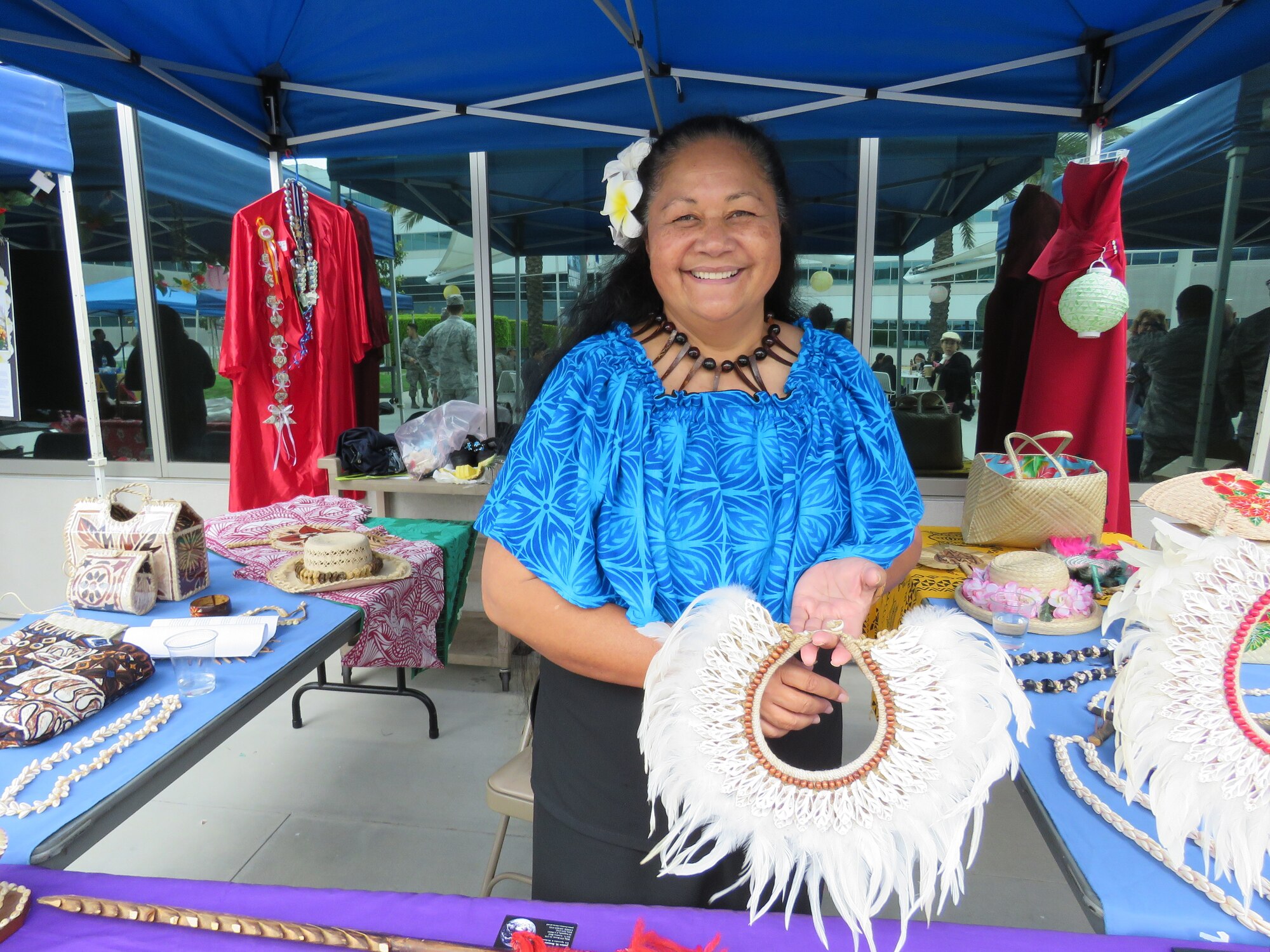 Malaea Fepuleai Toomalatai Coleman shows off a handmade feather and cut shell necklace.