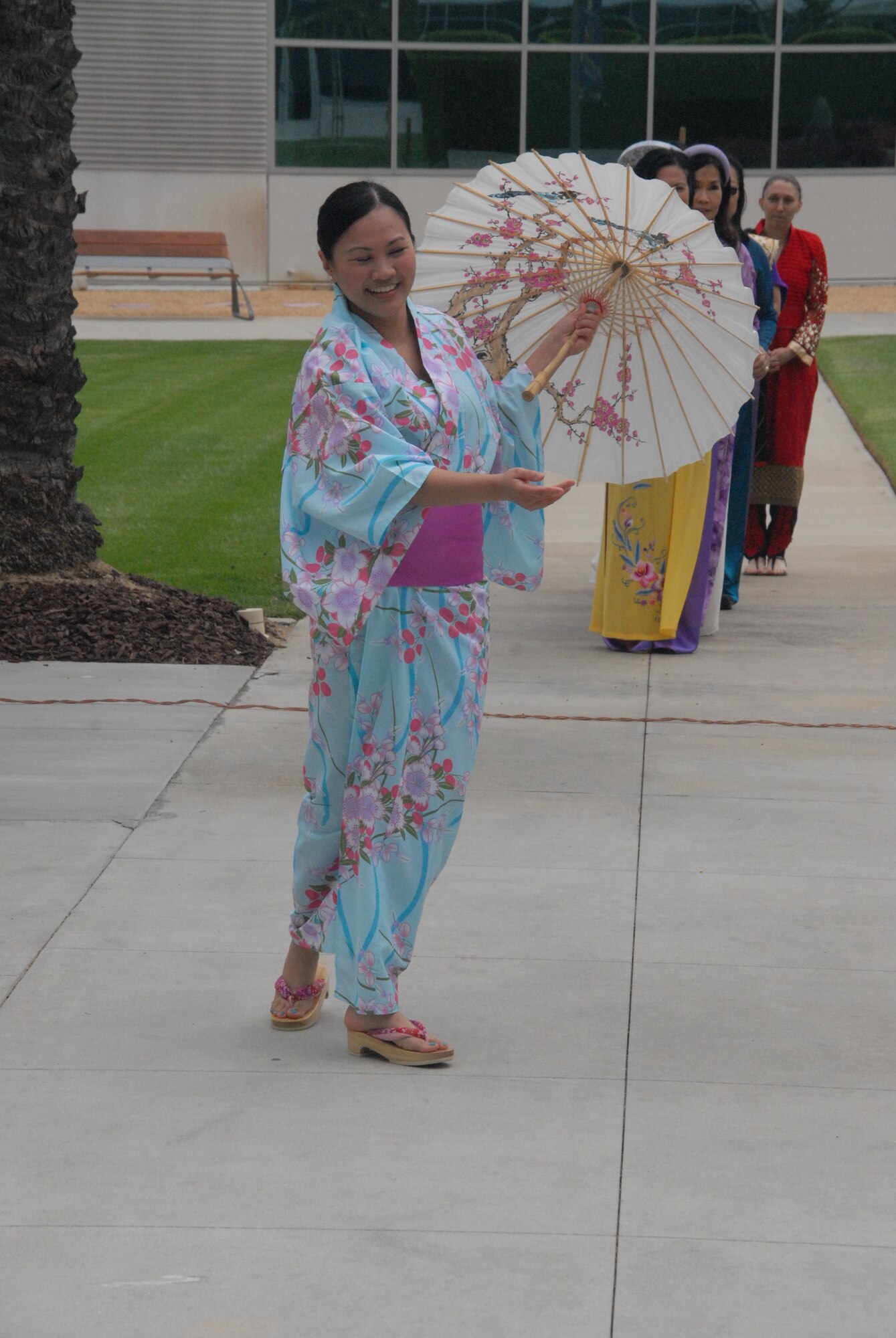 Tech. Sgt. Kristin Rosales, noncommissioned officer in charge of Medical Materiel at the 61st Medical Squadron, performs a traditional dance wearing a turquoise floral Japanese kimono.