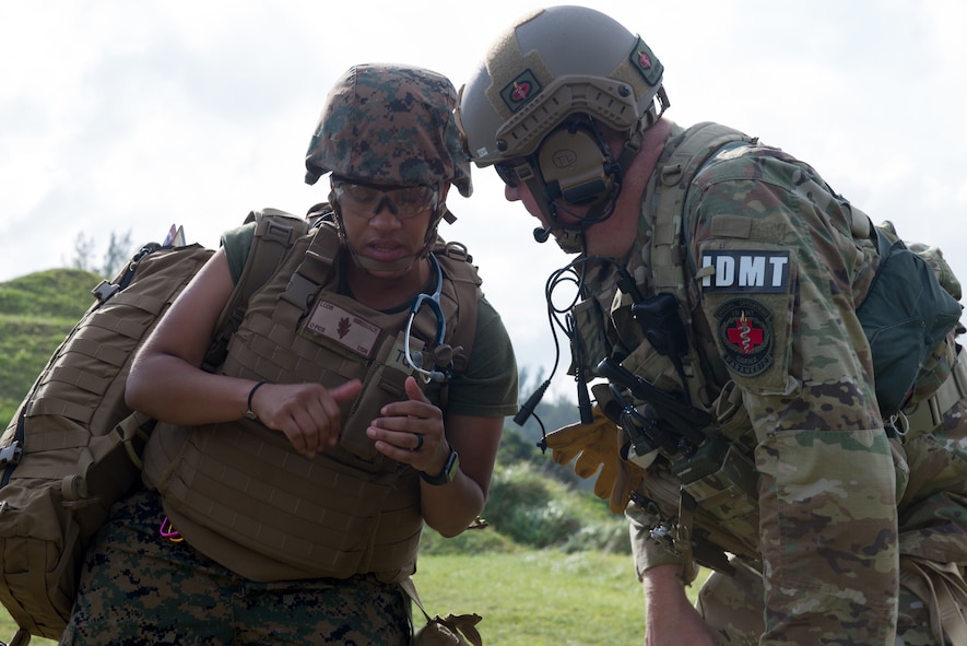 A U.S. Air Force Independent Duty Medical Technician, and a U.S. Navy sailor, prepare for a medical exercise aboard an MV-22 Osprey, June 6, 2018, at Marine Corps Air Station, Okinawa, Japan. The Air Force performs joint medical exercises with other U.S. forces regularly in Okinawa to better prepare service members for real world emergencies. (U.S. Air Force photo illustration by Josh Mahler)