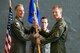 Col. Christopher Spinelli, 412th Operations Group Commander passes the 419th Flight Test Squadron guidon to Lt. Col. Thomas Meagher during a change of command ceremony June 15.