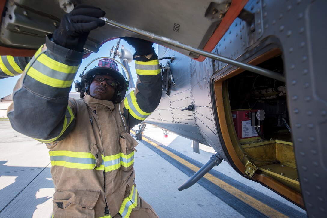 Staff Sgt. Tyler McFarland, 23d Civil Engineer Squadron (CES) firefighter, pulls up the hatch door to the battery of an HH-60G Pave Hawk, during a simulated rescue training scenario, June 19, 2018, at Moody Air Force Base, Ga. 23d CES firefighters conducted the training to evaluate their overall knowledge and preparation of how to properly shut down and rescue crew members from an HH-60. (U.S. Air Force photo by Airman 1st Class Eugene Oliver)