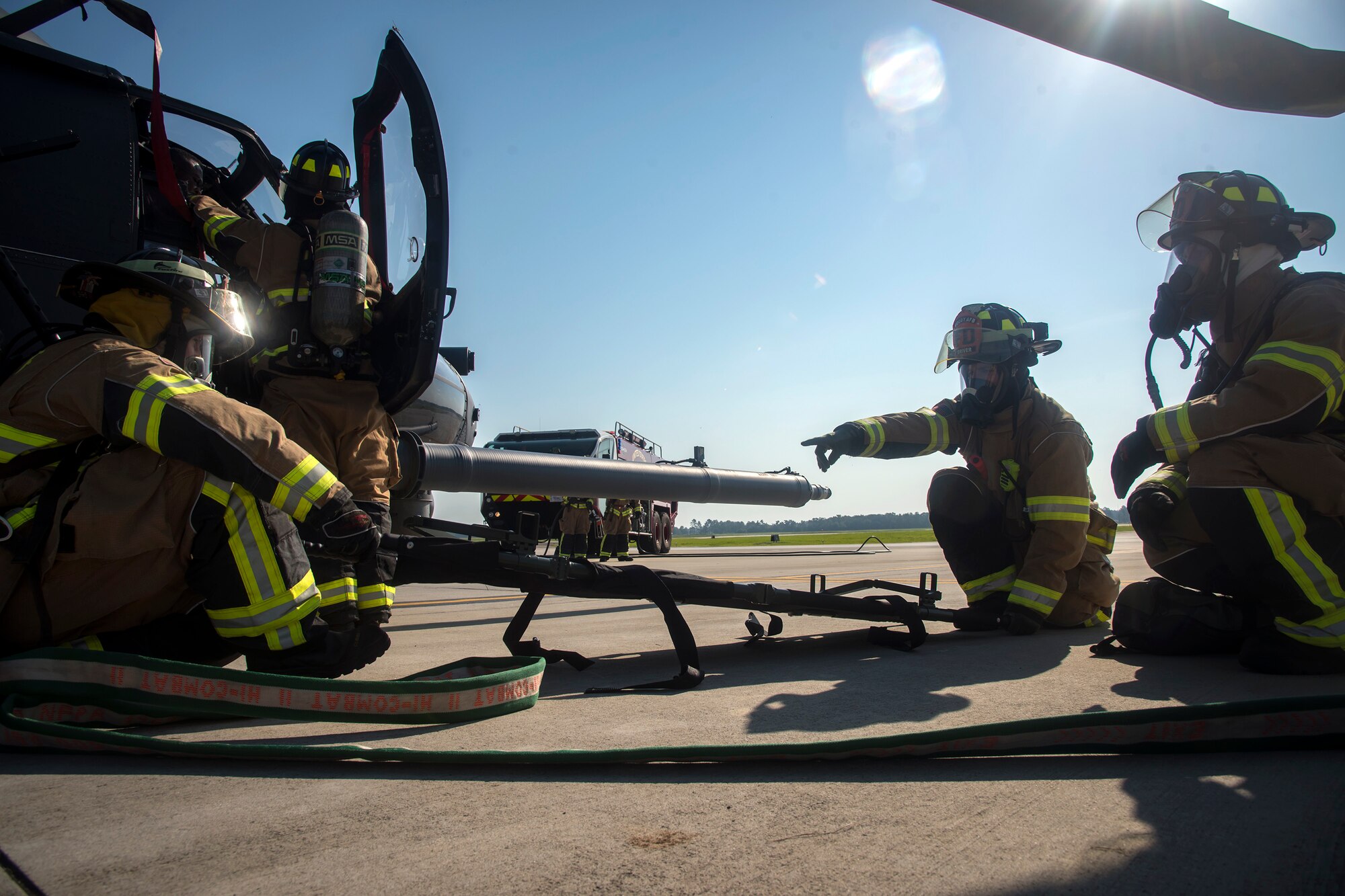 Firefighters from the 23d Civil Engineer Squadron (CES), install a backboard during an HH-60G Pave Hawk simulated rescue training scenario, June 20, 2018, at Moody Air Force Base, Ga. 23d CES firefighters conducted the training to evaluate their overall knowledge and preparation of how to properly shut down and rescue crew members from an HH-60. (U.S. Air Force photo by Airman 1st Class Eugene Oliver)