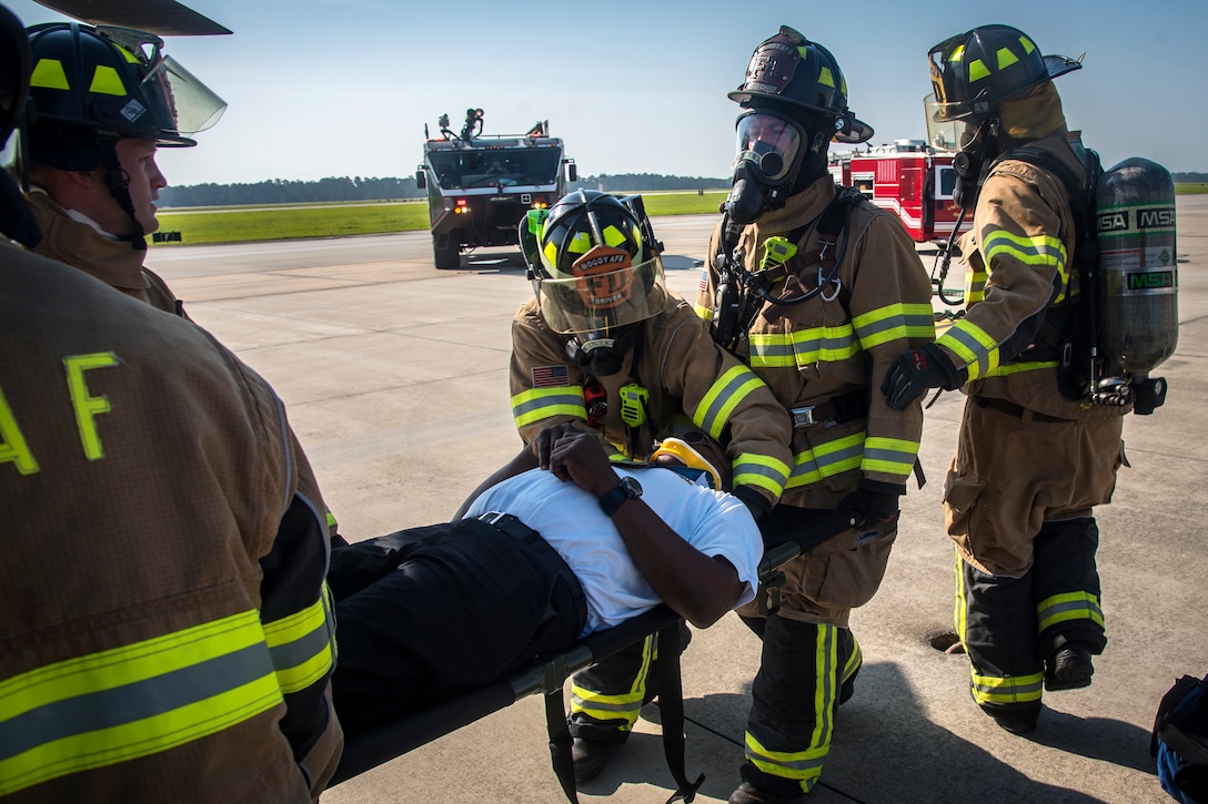 Firefighters from the 23d Civil Engineer Squadron (CES), secure Charlie Johnson, 23d CES assistant flight chief, during a HH-60G Pave Hawk simulated rescue training scenario, June 20, 2018, at Moody Air Force Base, Ga. 23d CES firefighters conducted the training to evaluate their overall knowledge and preparation of how to properly shut down and rescue crew members from an HH-60. (U.S. Air Force photo by Airman 1st Class Eugene Oliver)