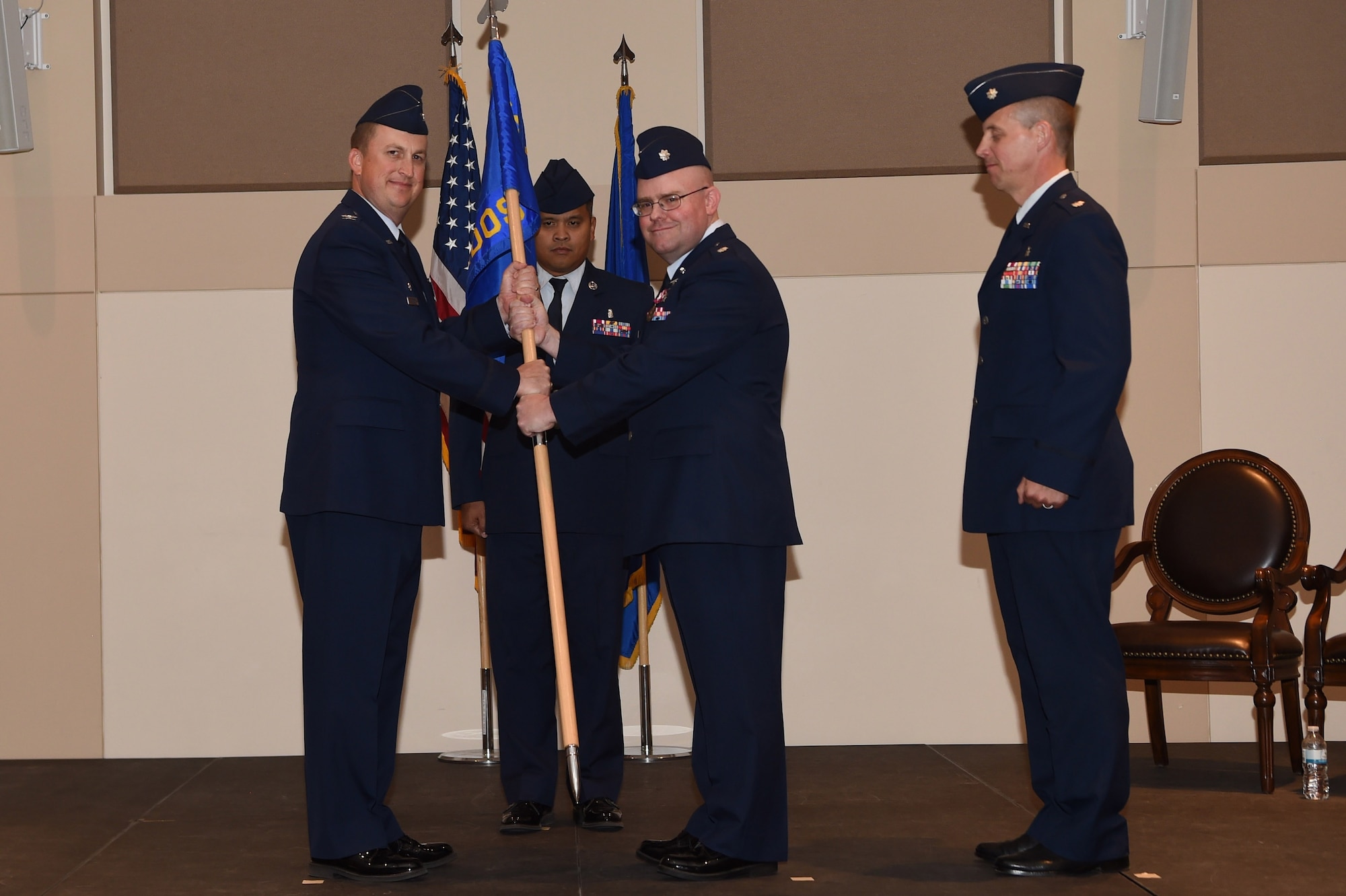 Lt. Col. Jon O’Pry, center, 460th Medical Operations Squadron outgoing commander, pass the guidon to Col. Lorenzo Bradley, left, 460th Operation Group commander June 15, 2018, on Buckley Air Force Base, Colorado. The 460th MDOS mission is to provide medical and preventive health care to all wing and associated non-flying personnel and their dependents. (U.S. Air Force photo by Airman 1st Class Codie Collins)