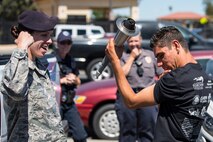 Special Olympian Eric Silva, holds the Special Olympics torch while flexing his muscles with Senior Master Sgt. Erin Rose, 60th Security Forces Squadron operations superintendent, after completing a portion of the 2018 Special Olympics Torch Run at Travis Air Force Base, Calif., June 20, 2018. The annual event brings law enforcement from the community and the base together to show their support for Special Olympics and the athletes who participate in the games. (U.S. Air Force Photo by Master Sgt. Joey Swafford)