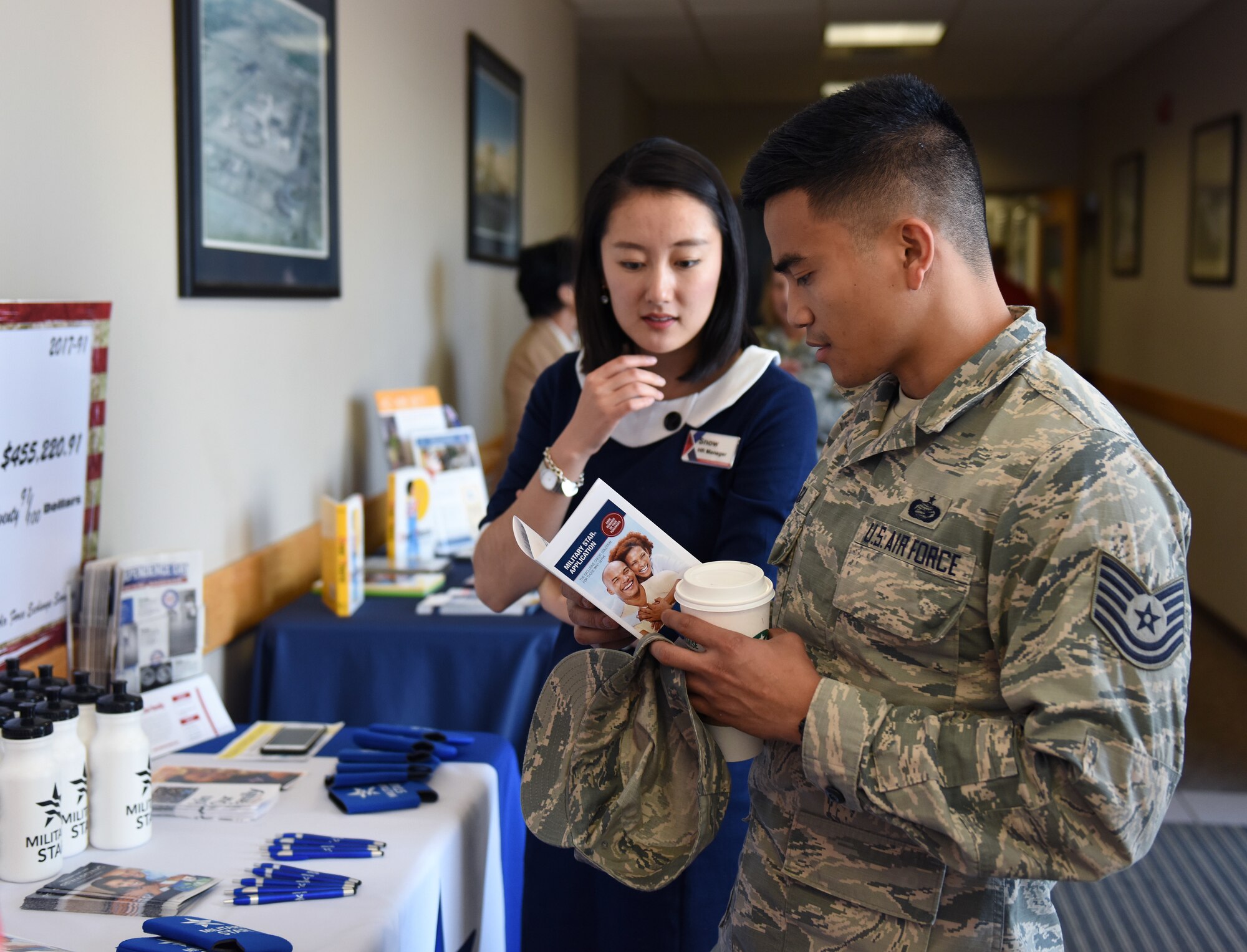 U.S. Air Force Tech. Sgt. Jomarie Banaga, right, the Air Force ROTC Det. 105 NCO in charge, learns about the Military Star Program from Snow Liu, left, the human resource manager at the Exchange, at Buckley Air Force Base, Colorado, June 20, 2018.