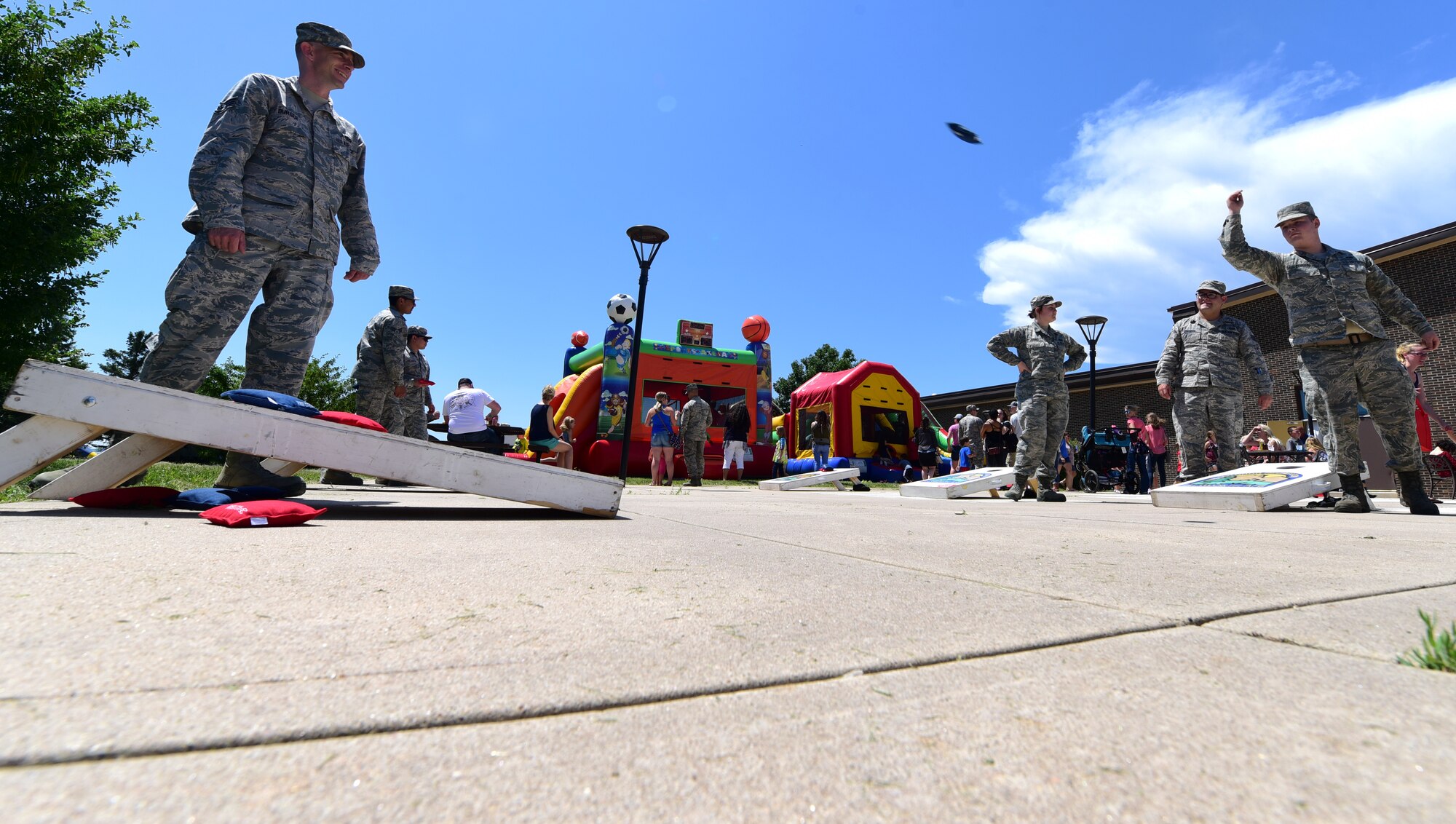 Airmen participate in a game of cornhole during the annual base picnic outside the Dakota’s Club at Ellsworth Air Force Base, S.D., June 22, 2018. The purpose of the base picnic was to thank the members of Ellsworth for their hard work, as well as celebrate the start of summer. (U.S. Air Force photo by Senior Airman Randahl Jenson)