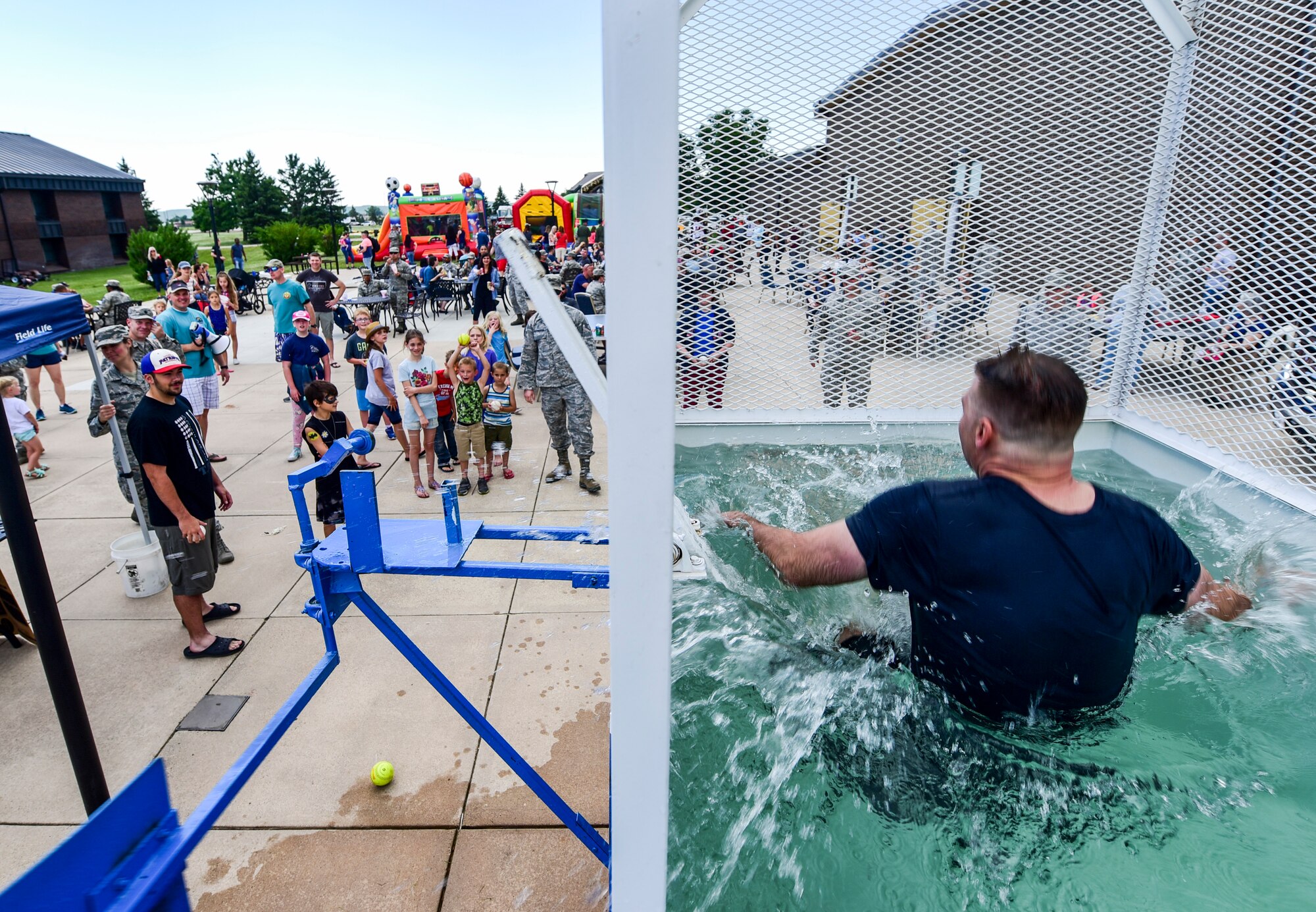 Senior Master Sgt. Edward Mueller, 28th Logistics Readiness Squadron superintendent of fuels management, falls into a dunk tank during the annual base picnic outside the Dakota’s Club on Ellsworth Air Force Base, S.D., June 22, 2018. The dunk tank event was part of the Air Force Ball Dunk-a-Leader fundraiser, which involved nominating base leadership to be dunked in a tank of water, and the money raised from the event will go toward the base’s 2018 Air Force Ball in September. (U.S. Air Force photo by Senior Airman Randahl J. Jenson)