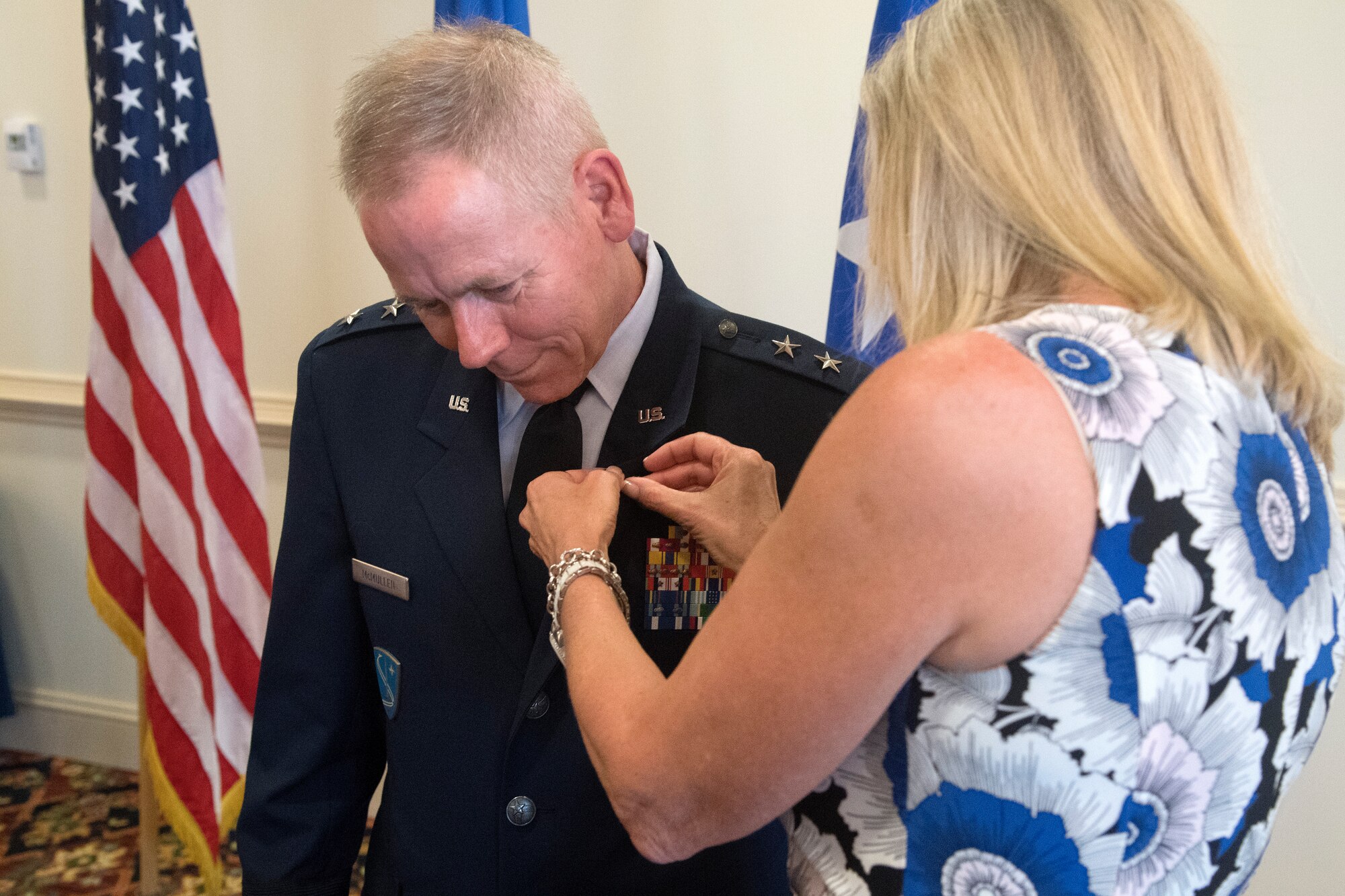 Kim McMullen attaches a retirement lapel pin on Maj. Gen. John K. McMullen, the deputy commander of Air Combat Command, during his retirement ceremony