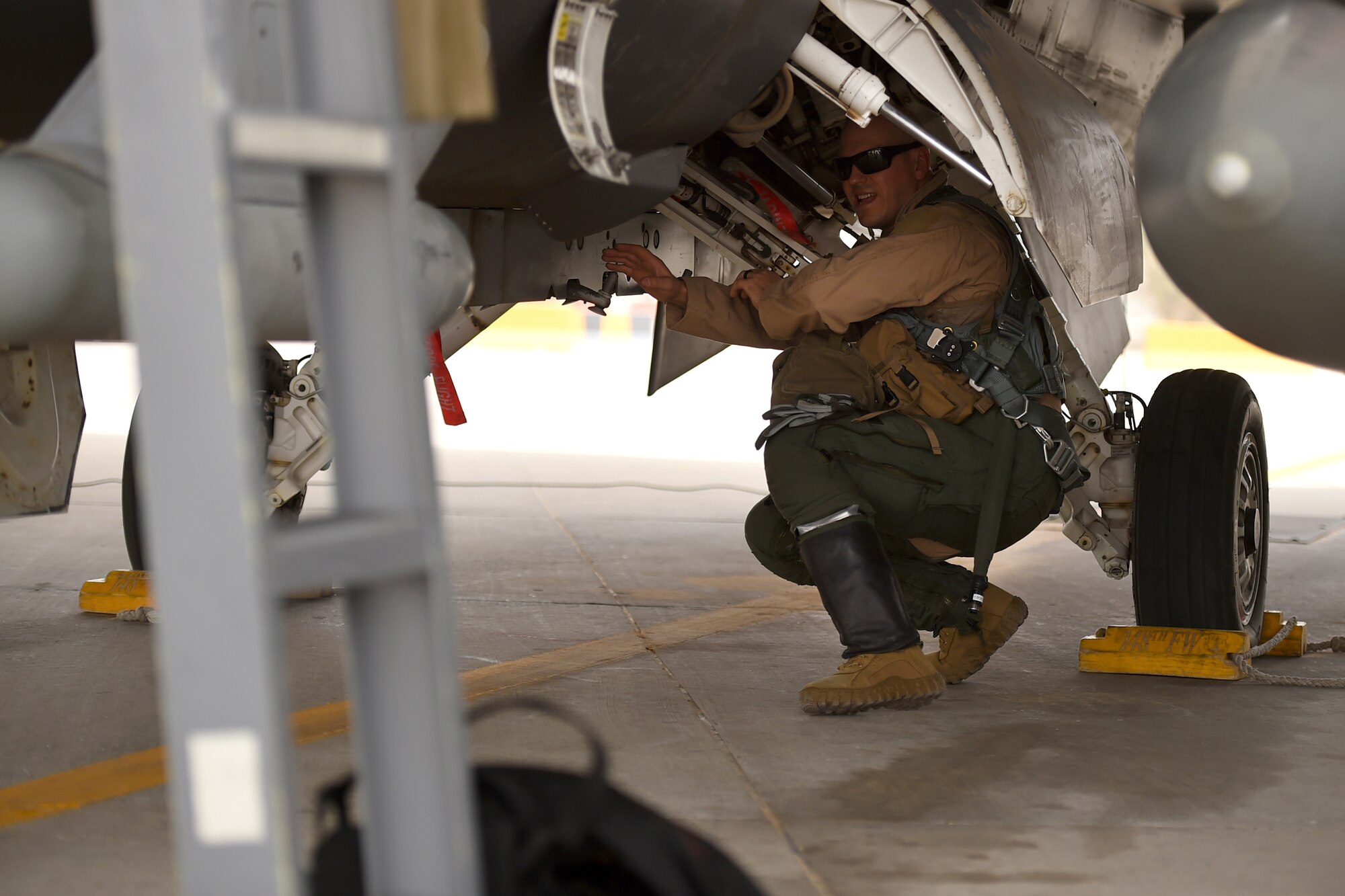A pilot check underneath a fighter jet