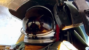 Pilot wearing helmet in cockpit