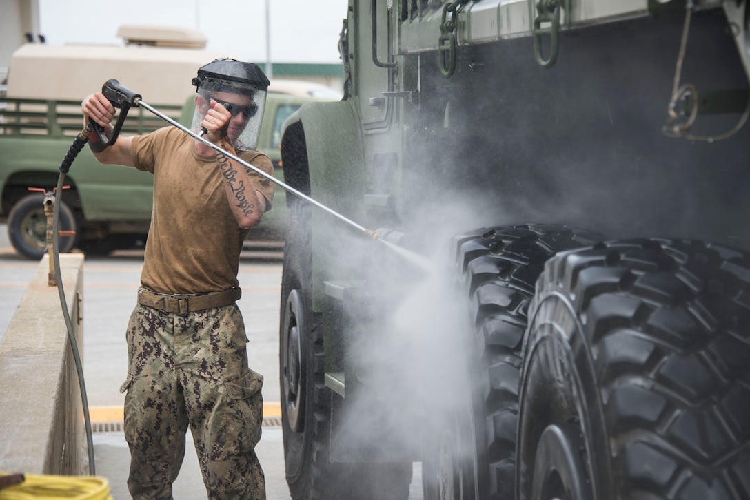 Builder Constructionman Stephen Wetmore, from Deltona, Fl.,  assigned to Naval Mobile Construction Battalion (NMCB) 5, washes down a vehicle during a 48-hour Mount-Out Exercise (MOX) in Okinawa, Japan June 19. The MOX simulates one of the core capabilities of a construction battalion to deploy an air detachment, along with construction equipment, within 48-hours to any required location around the globe. NMCB 5 is forward deployed to execute construction, humanitarian and foreign assistance, and theater security cooperation support of United States Pacific Command.