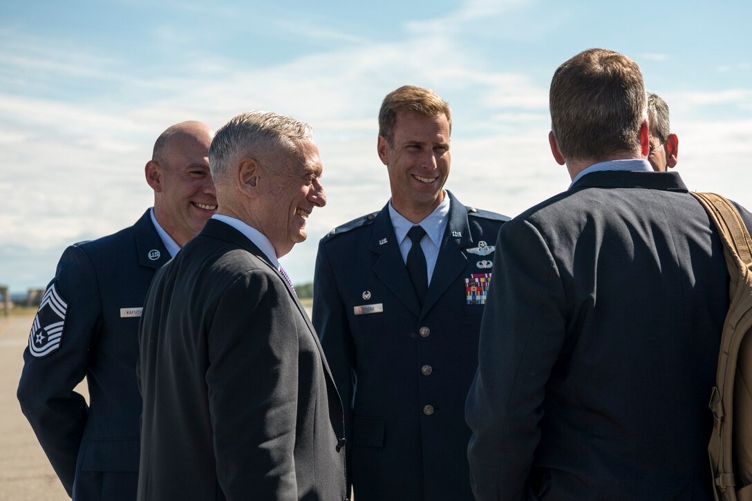 Defense Secretary James N. Mattis talks with officials on a flightline.
