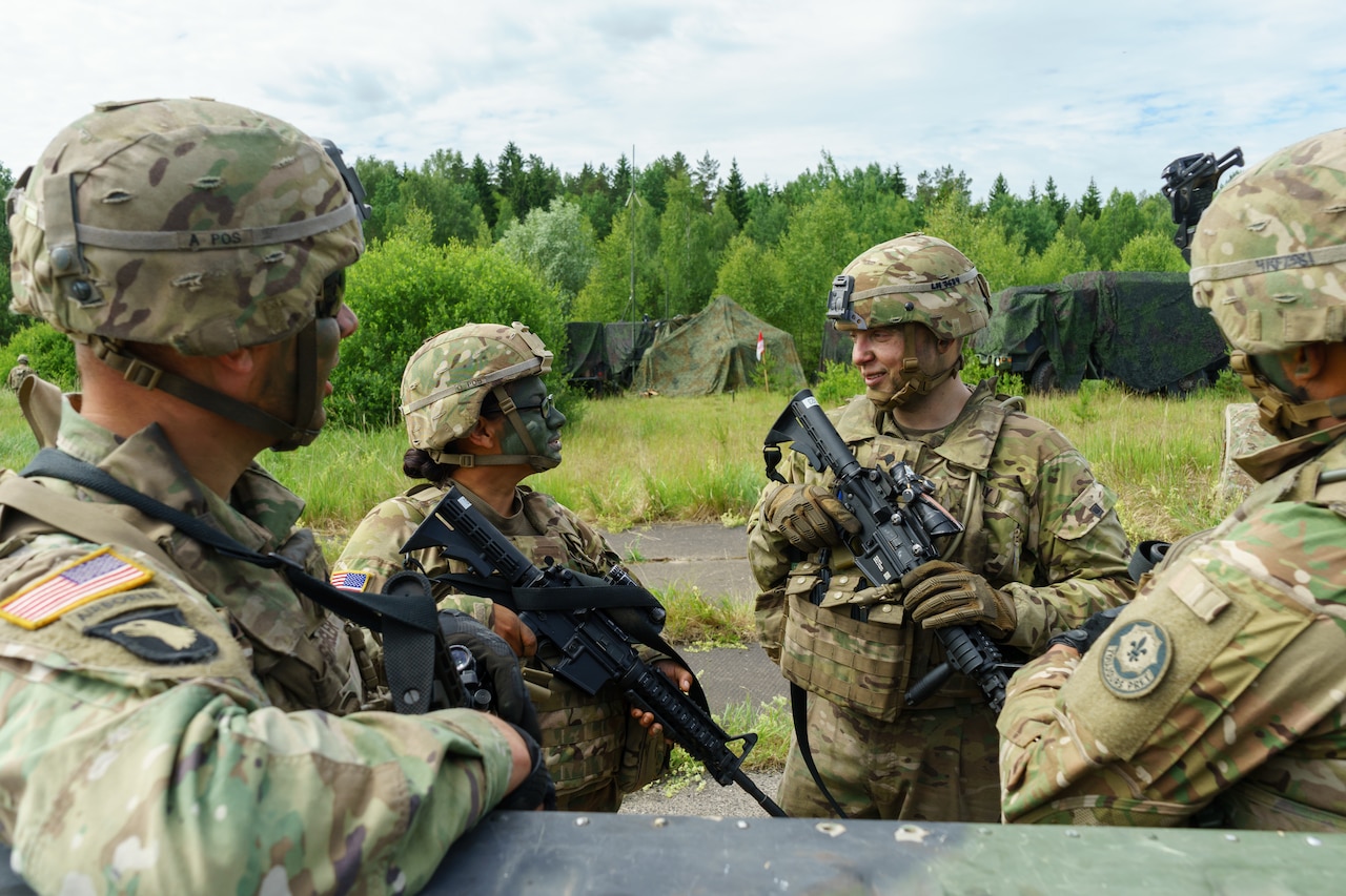 Army Spc. Lukas Natkevicius, second from right, a cavalry scout and Marijampole, Lithuania, native assigned to Headquarters and Headquarters Troop, 4th Squadron, 2nd Cavalry Regiment, smiles during a conversation with troops of his unit during Exercise Saber Strike 18 at a training area near Kazlu Ruda, Lithuania, June 7, 2018. Army photo by Sgt. Gregory T. Summers