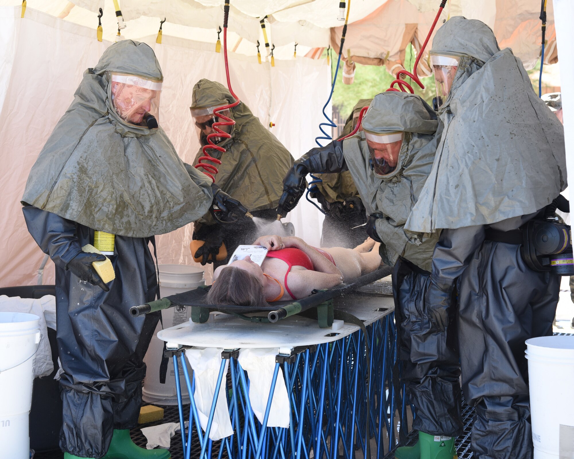 Members of the 161st Air Refueling Wing process a patient through an In-Place Patient Decontamination station during an exercise at the Goldwater Air National Guard Base, May 22, 2018. The purpose of the exercise was to train and evaluate the IPPD team's ability to decontaminate and prepare a patient to be transported onto a higher level of medical care. (U.S. National Guard photo by Staff Sgt. Wes Parrell)