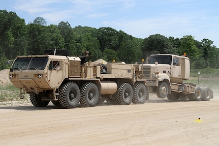 A Heavy Expanded Mobility Tactical Truck (HEMTT) A4 wrecker with the 211th Maintenance Company out of Newark, Ohio, tows a M915A5 truck tractor with the 1487th Transporation Company out of Piqua, Ohio, while completing tactical convoy operations training June 21, 2018, at the Camp Grayling Joint Maneuver Training Center in Grayling, Michigan.