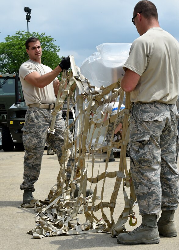 Staff Sgt. Nick Bailey and Tech Sgt. Richard Bauer prepare to place a cargo net on a pallet packed with supplies on the Youngstown Air Reserve Station flightline, June 3.