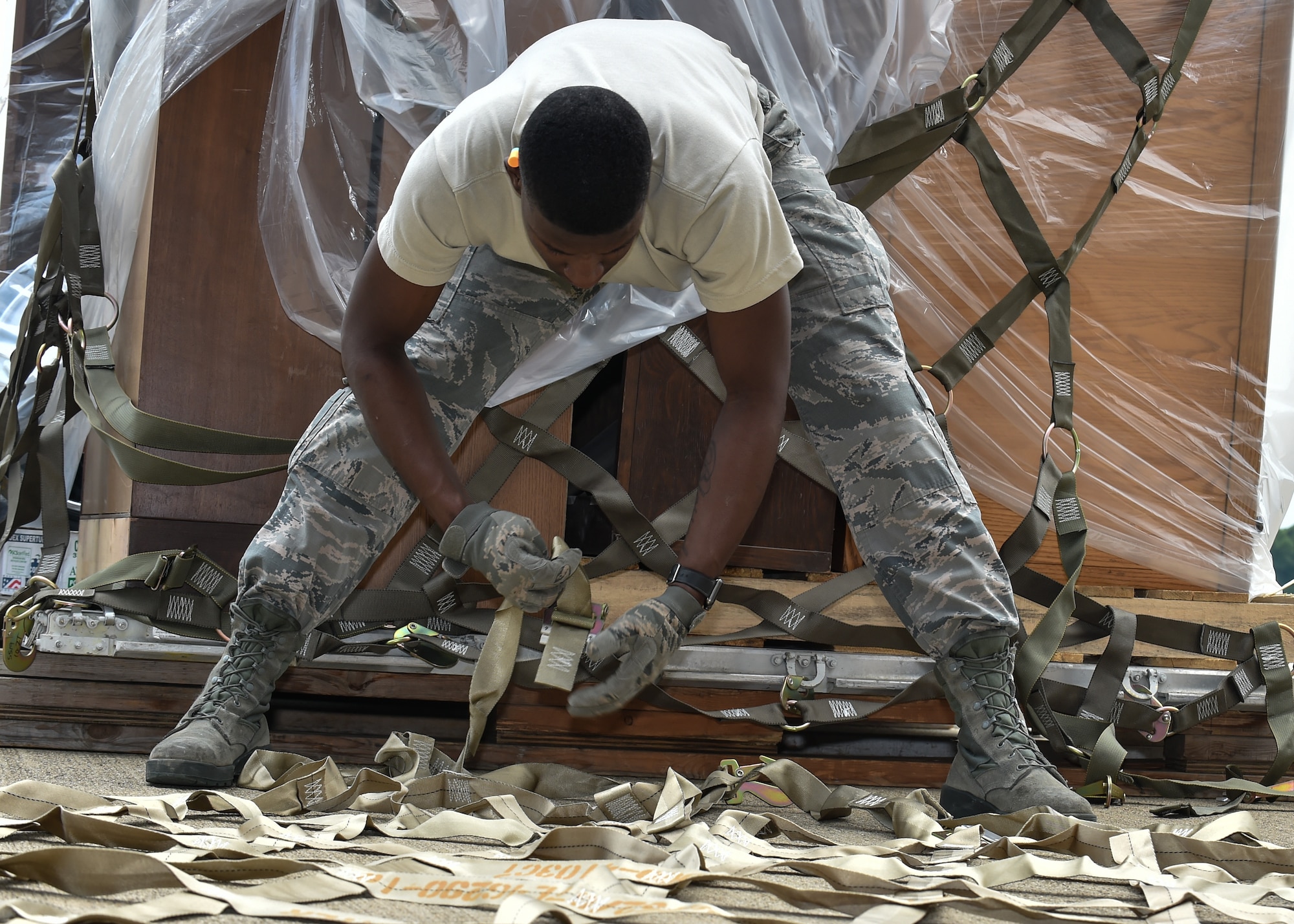 Airman 1st Class Kevin Mills, a 76th Aerial Port Squadron (APS) aerial transporter, lays out a cargo net  on the Youngstown Air Reserve station flightline, June 3.