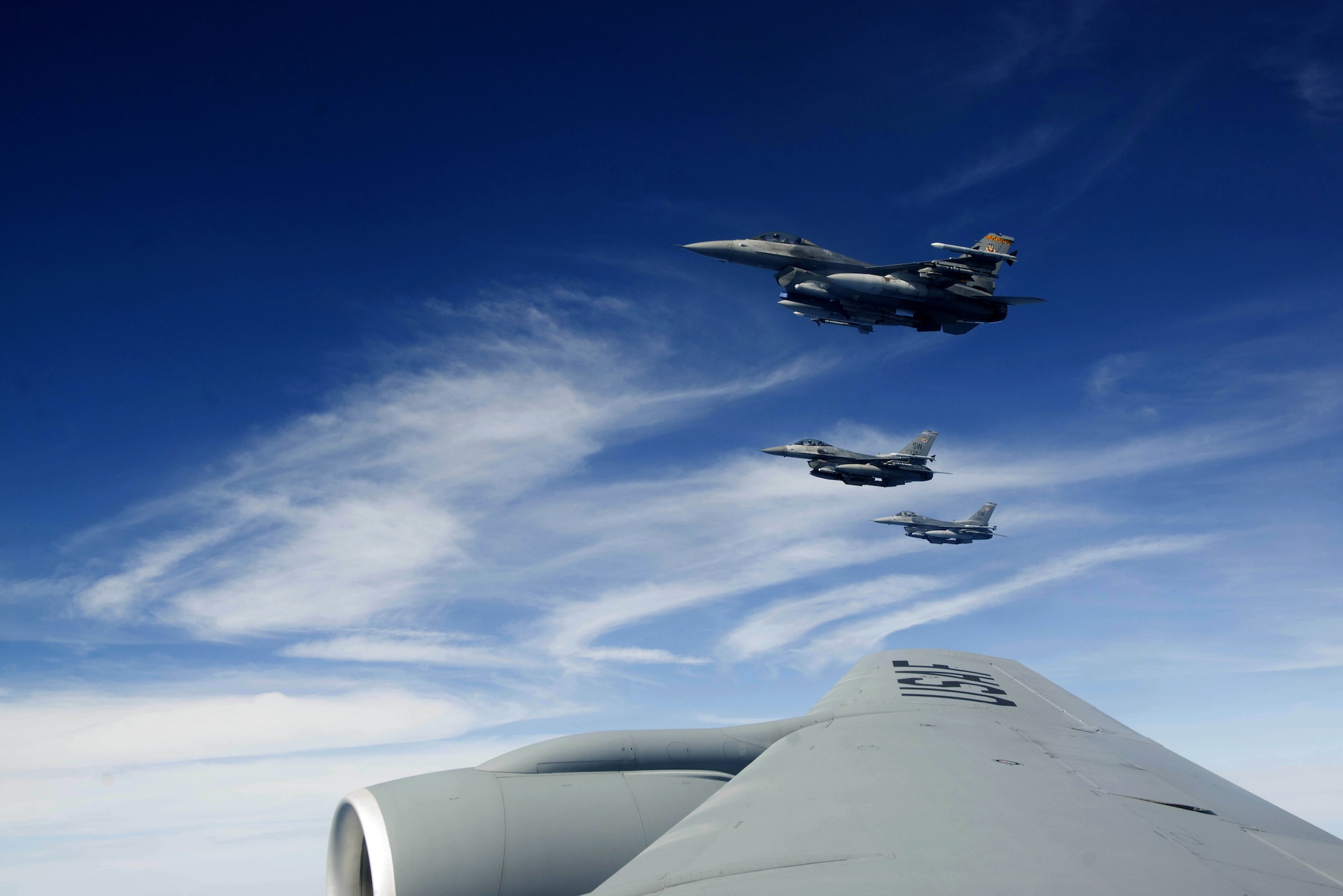 Three U.S. Air Force F-16CM Fighting Falcon pilots escort a 72nd Air Refueling Squadron KC-135R Stratotanker above the Atlantic Ocean, June 19, 2018.