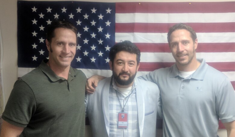 Matt and Justin Scherzberg pose with a friend in front of the U.S. flag at Camp Marmal in Mazar-e-Sharif in Afghanistan.