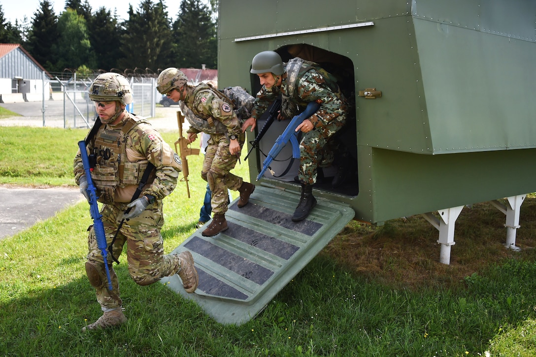 Soldiers dismount a Stryker vehicle mockup during training.