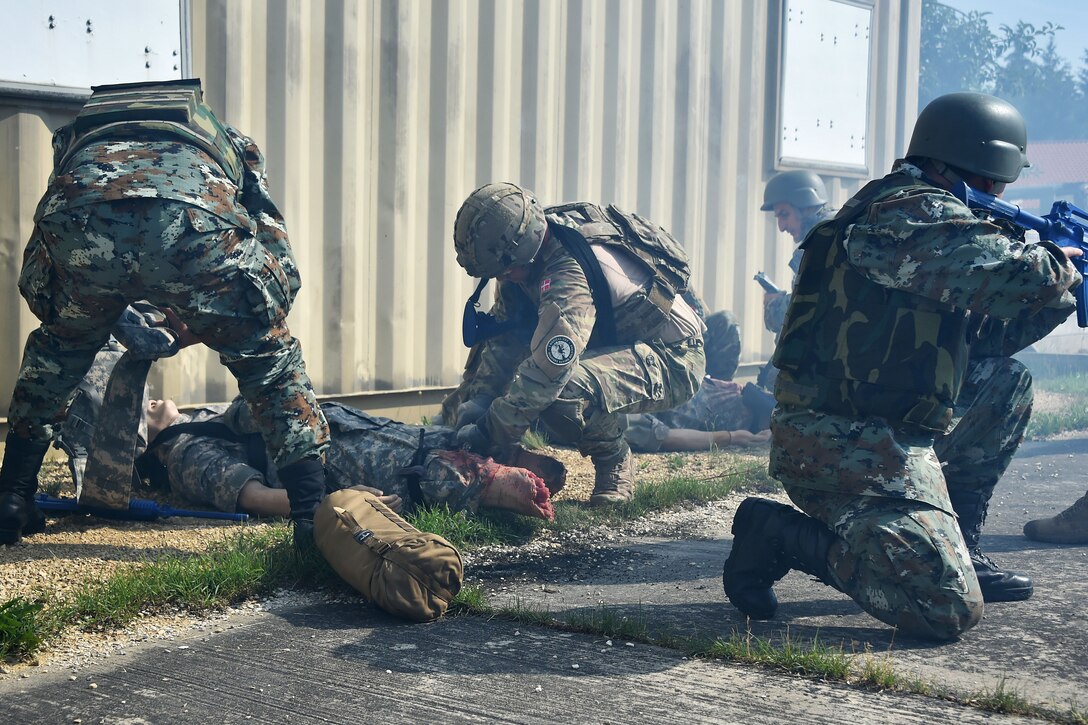 Soldiers practice first aid on a simulated casualty during training.