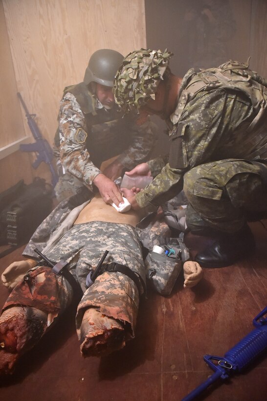 Macedonian and Kosovar soldiers apply first aid to a simulated casualty.