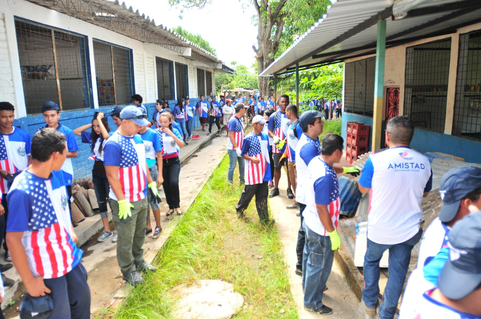 Volunteers, students, and U.S. service members gather to clean up trash and debris as part of Friendship Day at a Beyond the Horizon 2018 school construction site in the area of Zacatecoluca, El Salvador, June 15, 2018. The original school building was cluttered with debris such as scrap metal, wood and trash.